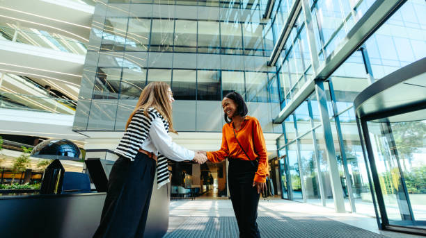 istock Professional greeting between colleagues in modern office lobby 2184564640
