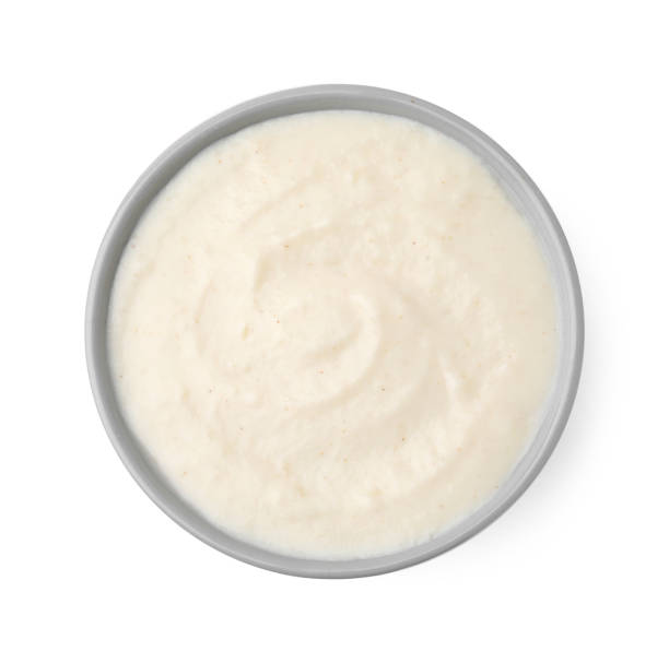 istock Delicious semolina pudding in bowl isolated on white, top view 2184565067