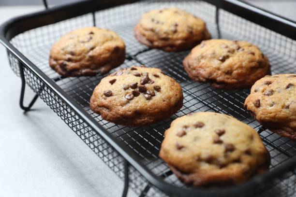 istock Cooling rack with delicious chocolate chip cookies on light grey table, closeup 2184565421