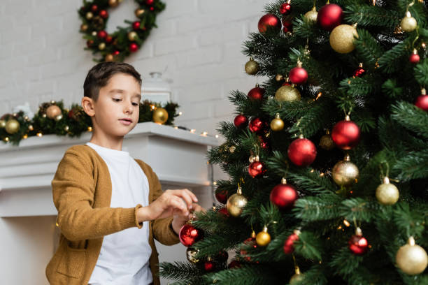 istock A joyful boy  celebrates Christmas in a beautifully decorated modern apartment with a tree 2184566011