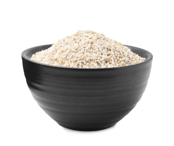 istock Dry barley groats in bowl isolated on white 2184567554