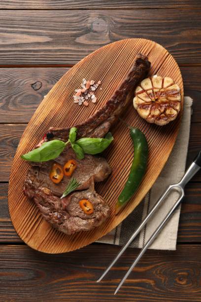 istock Delicious fried beef meat served on wooden table, flat lay 2184567885