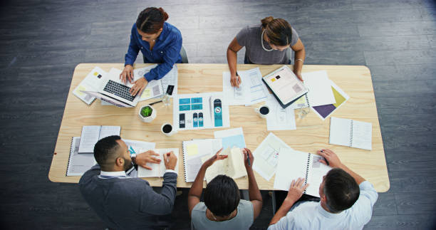 istock Above, planning and group with documents, office and collaboration for project, laptop and business. Desk, digital marketing and paperwork for ad campaign, people and teamwork for social media 2184569238