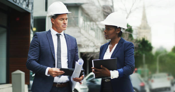 istock Engineering, people and document in city for planning, urban development and project management. Architecture team, discussion or checklist at meeting for inspection, contractor feedback and business 2184569249