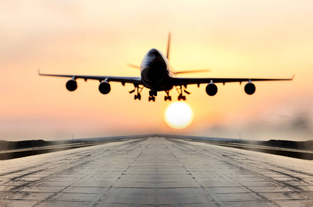 istock Passenger airplane is landing at sunset 2184571377