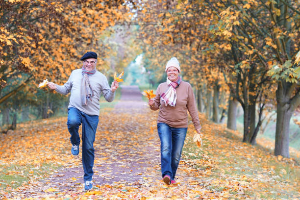 istock mature couple jumping threw the fall season 2184574601