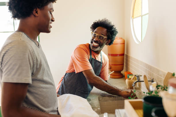 istock Father and son washing hands with clay filter water at the kitchen sink 2184574687