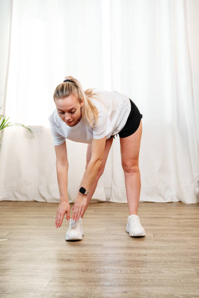 istock A young woman stretches during a home workout session in a bright room 2184575492