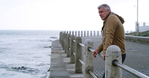 istock Mature man, thinking and stress by beach with outdoor, planning or reflection for break on weekend. Male person, mental health and wellness by seaside, ocean or water for space, memory or mindfulness 2184576196