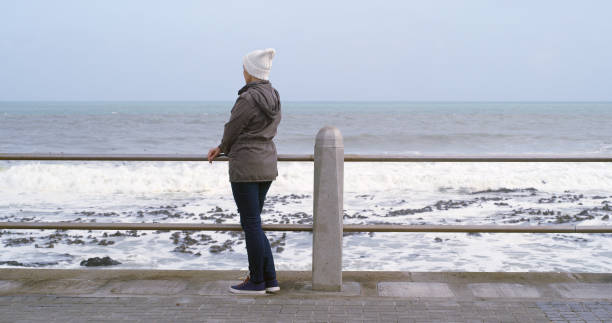 istock Back, woman and thinking with outdoor by ocean for relax, planning and reflection on weekend. Female person, mental health and wellness by seaside or water for ideas, memory and mindfulness for break 2184576231