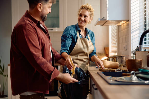 istock Happy couple talking while preparing food together in the kitchen. 2184578794