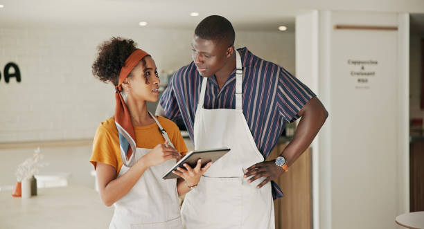 istock Partnership, tablet and small business with people in cafe for planning, teamwork and startup renovation. Waiter, hospitality and menu research with man and woman in coffee shop for cafeteria 2184579388
