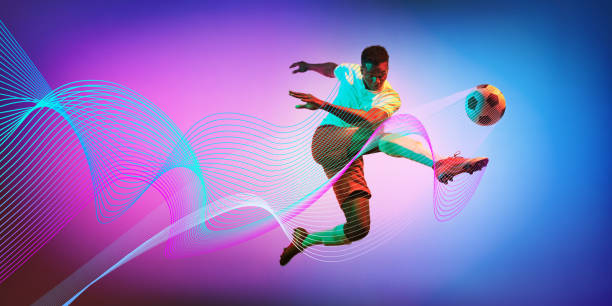 istock Powerful kick. Man, soccer player in motion during game, kicking ball against gradient background with neon lines wave elements 2184580307