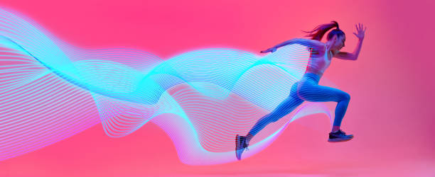 istock Dynamic image of athletic young woman, runner in motion, running against pink background with abstract neon lines elements. 2184580310