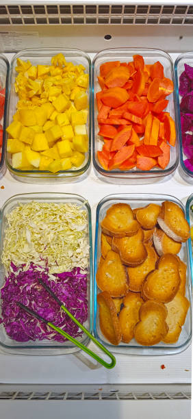 showcases a neatly arranged bowl of salad, offering a vibrant and colorful assortment of ingredients. Diced yellow fruit, possibly pineapple, pairs beautifully with sliced orange fruit, like papaya.