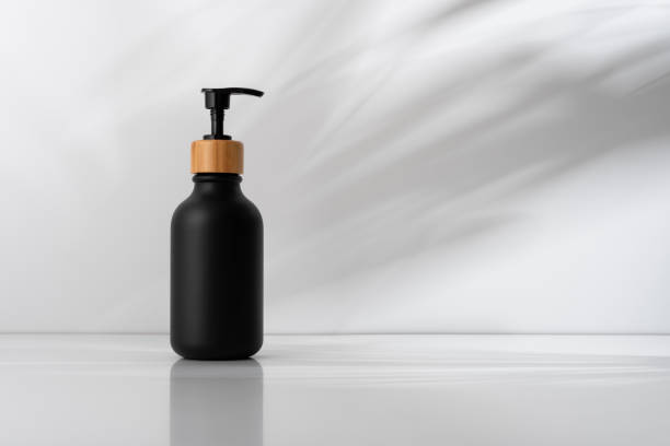 istock Black soap dispenser with bamboo lid, minimalist design on a soft shadows background 2184584261
