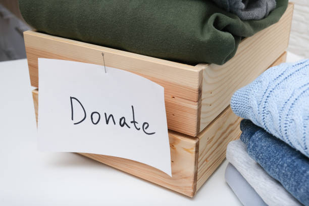 istock A wooden box is filled with clothes and contains a note that says donate 2184584280