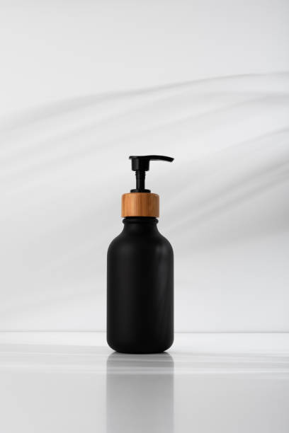 istock Black soap dispenser with bamboo lid, minimalist design on a soft shadows background 2184584289