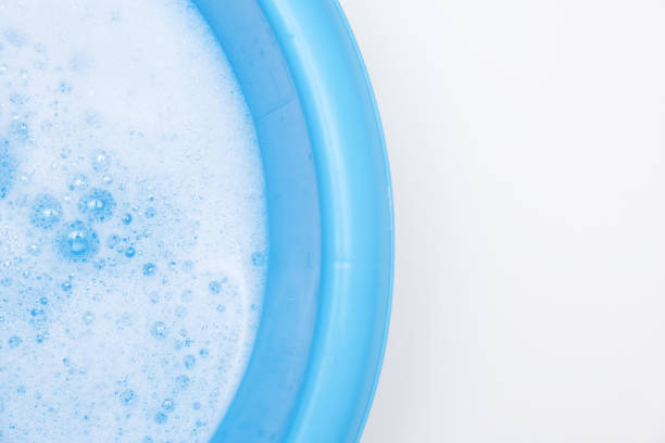 istock Blue basin with water and white foam bubbles foam water soap suds texture foam close up, copy space 2184584445