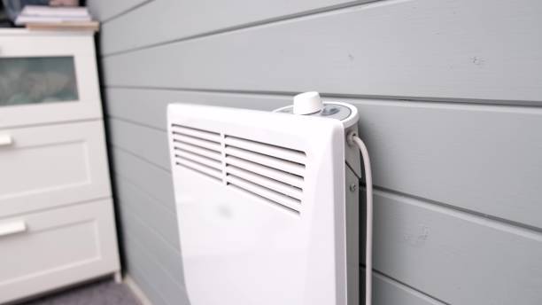 istock Heat regulating, setting temperature on electric convector, heater thermostate in the room in winter, climate control and energy saving concept 2184584648