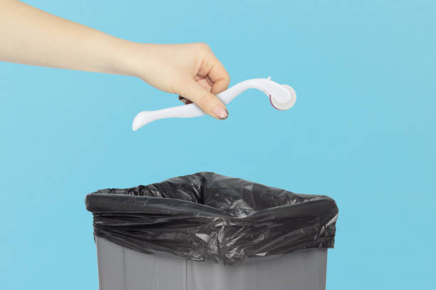 istock throw a Mesoscooter, mesoscooter Dermaroller. Device for cosmetic mesotherapy procedures into the trash bin, hold а mesoscooter in your hand in front of a trash can 2184588245