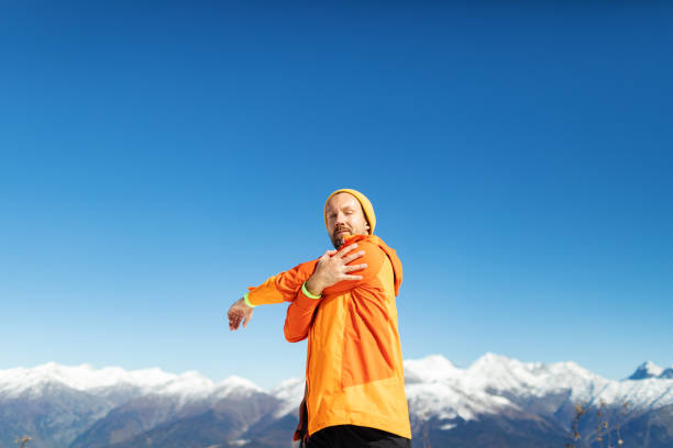 Mid adult man warming up before sport training in mountain