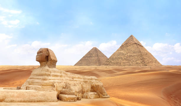 istock Famous Great Sphinx and pyramids of Chephren and Cheops, Cairo, Egypt. Great Pyramids, ancient statue of Sphinx and beautiful sand dunes, Giza complex (Giza Necropolis) 2184599069