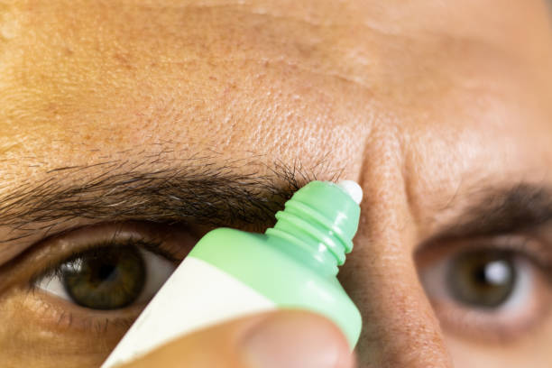 istock Man is applying anti wrinkles cream.Frown lines between eyebrows on mans face. Vertical wrinkles, close up. 2184601557
