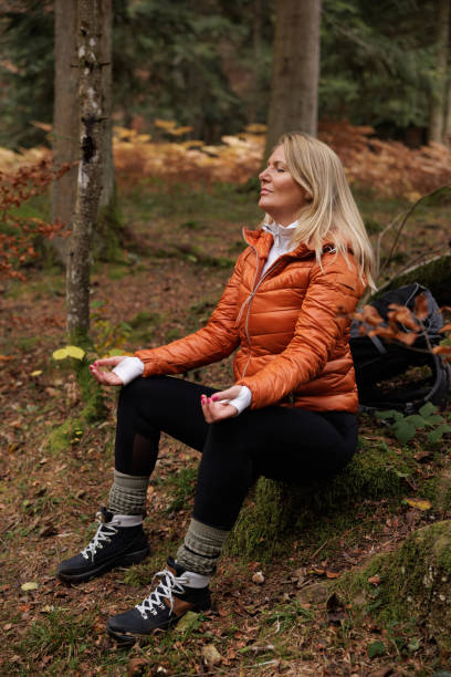 istock Woman Meditates Peacefully in Autumn Forest Setting 2184602386