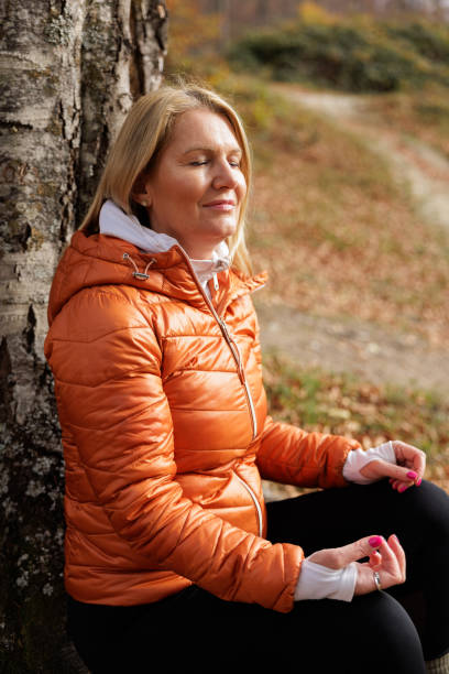 istock Woman Meditates Peacefully in Autumn Forest Setting 2184603177