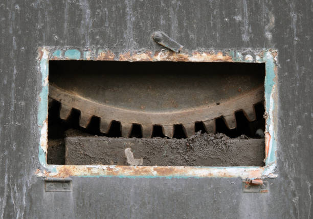 Rusty metal gear, part of which can be seen through the window.