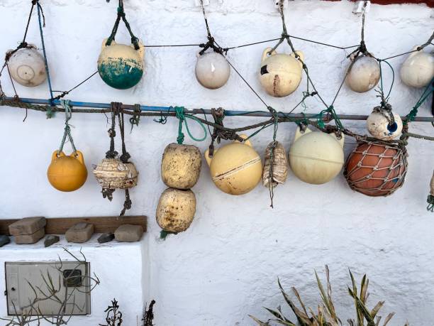 Different old ship fenders, a kind of ship protection, attached with ropes over a white wall in Agaete, Las Palmas de Gran Canaria, Canary Island, Spain. Sightseeing Las Palmas de Gran Canaria, Canary Island, Spain.Spain travel concept.