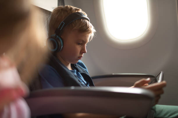istock Little boy traveling on airplane using a tablet. 2184608985