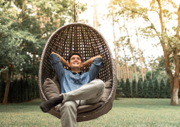 Happy young man smiling relaxing in his yard.