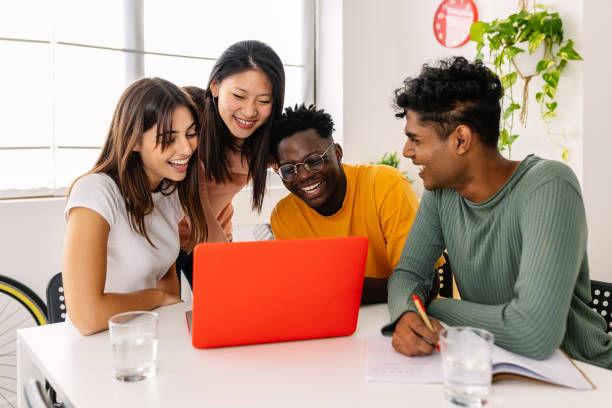 istock Group of cheerful millennial students study together at home. 2184609647