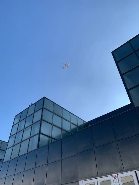 istock Plane in the sky between buildings 2184611780