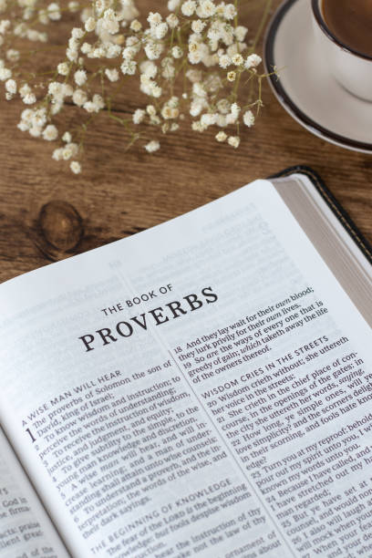 istock Proverbs open holy bible book with cup of coffee on wooden table 2184614560