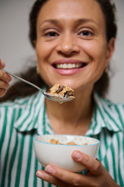 istock Smiling woman enjoying a healthy breakfast with cereal 2184616373