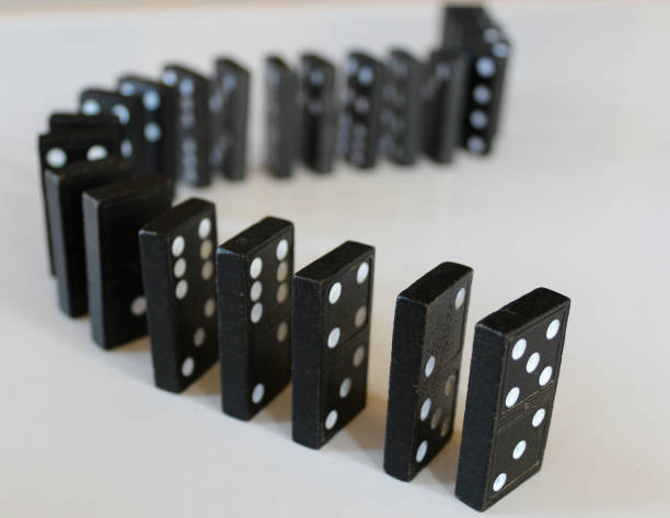 istock lined up in a row and curved standing black dominoes isolated on white background 2184619435