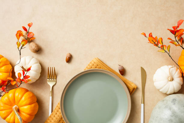 istock Autumn table setting with pumpkins, leaves, acorns, and cutlery on a beige background. Thanksgiving dinner concept 2184620785