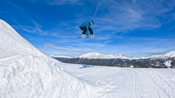 istock LOW ANGLE: Young male snowboarder rides off a kicker and does a cool grab trick. 2184625572
