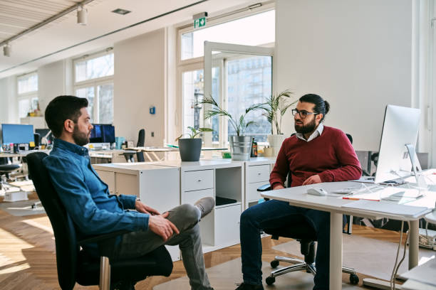 istock Businessmen discussing new project at desk in startup office 2184628043