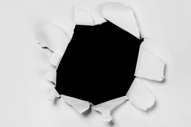 istock Torn Hole in White Paper Revealing Black Background 2184629625