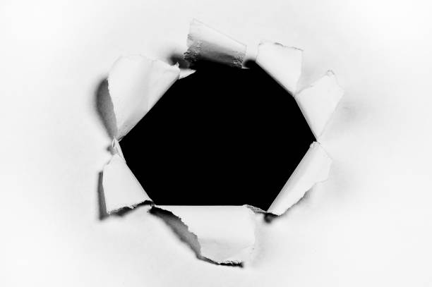 istock Torn Hole in White Paper Revealing Black Background 2184629678