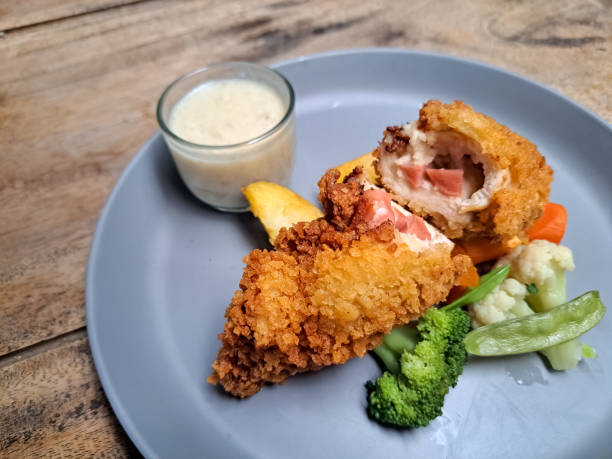 Tasty Chicken Cordon Bleu With Potato Wedges, Snow Peas, Brocolli, Carrot And Mushroom Sauce. Food Menu.