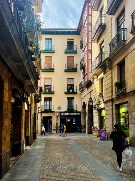 Pedestrians and tourists walking along Calle Liberta, a small street in Bilbao, Spain. October 2023
