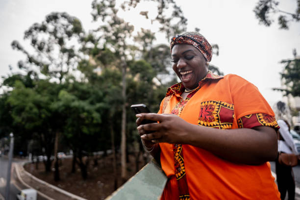 istock Mature woman using the mobile phone outdoors 2184634159