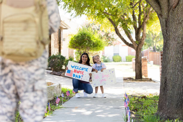 istock Cheerful mom and daughter welcome home returning soldier 2184635659