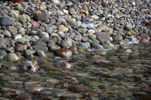 Shallow depressions filled with water on the rocky shore of Grand Marais, Minnesota, USA