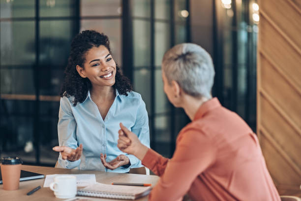 istock Two beautiful businesswomen talking 2184637159